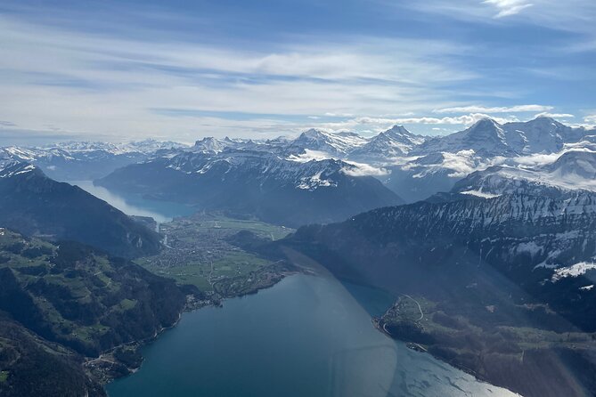 Private Swiss Alps helicopter tour over snow covered mountain peaks and glaciers - The changing colors of Lake Thun and Lake Brienz